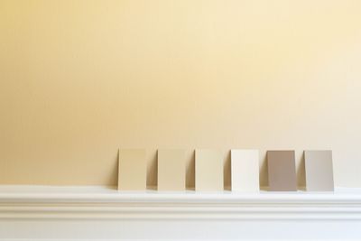 Various neutral color swatches against a light-yellow wall 