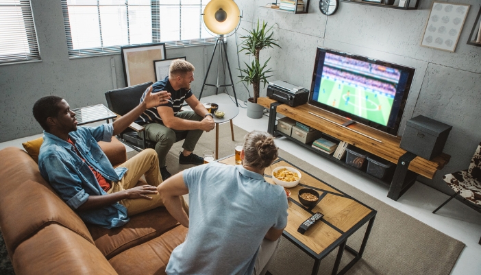 Furn_Game-Day-Furniture_1.jpg Friends watching football on a comfy sofa and chair