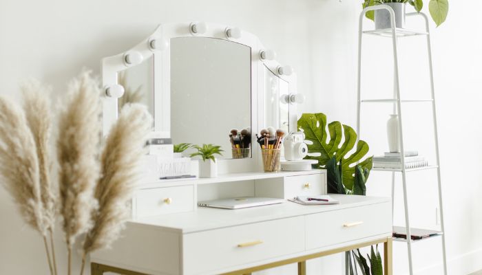 Brightly lit white vanity table with mirror and small shopping bags