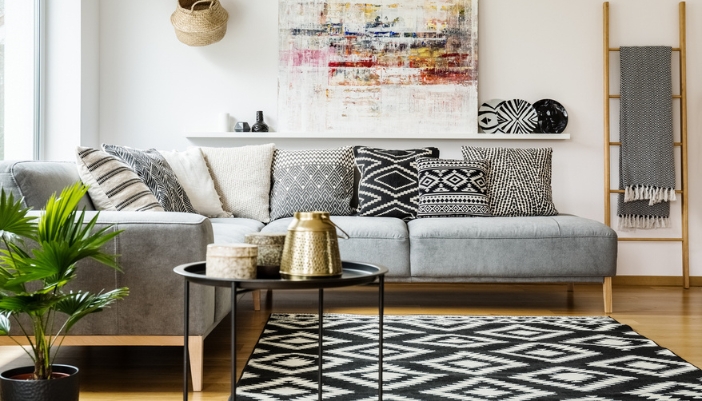 A natural colored living room with bold white and black patterned accents.
