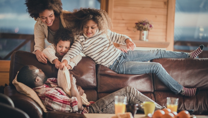 Furn_Childproofing-Furniture_2.jpg Family being playful around dad laying down on the leather couch