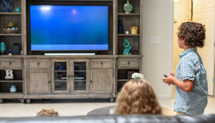 Furn_Childproofing-Furniture_3.jpg Family watching TV that’s been secured to the entertainment center
