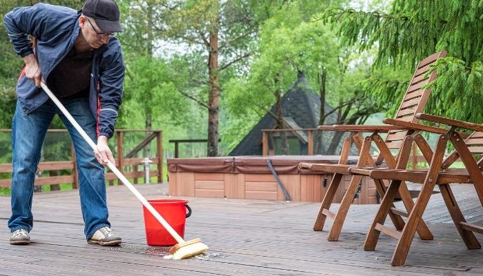 Furn_Protect-Outdoor-Furniture_2.jpg Man cleaning outdoor patio, scrubbing the floor
