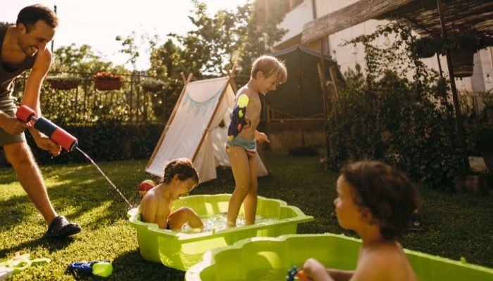 Furn_Summer-Kids-Activities_3.jpg Family having fun with water guns and buckets