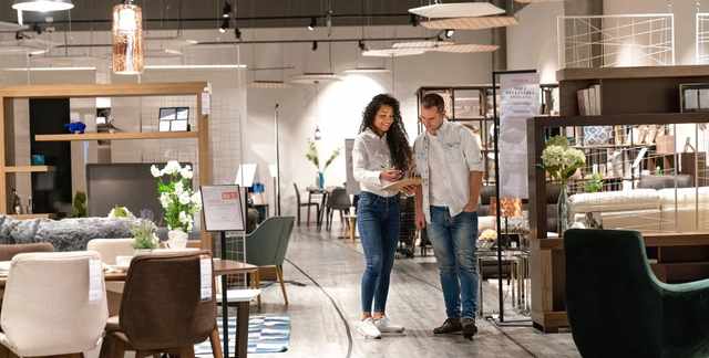 Credit: iStock Front view of a man and woman walking through a furniture store