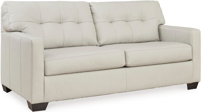 A beige leather sofa in a living room setting A beige leather sofa in a living room setting