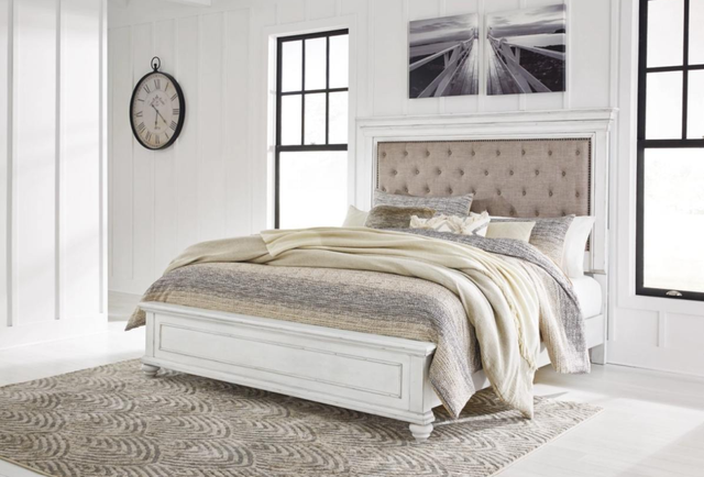 front view of a modern white bedroom with a white upholstered benchcraft king bed frame