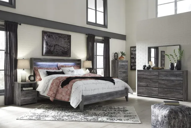 view of a transitional bedroom with a grey wooden king bed frame and matching furniture throughout