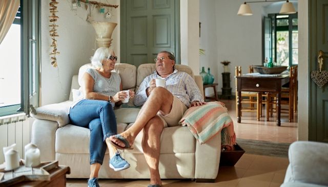 Front view of a modern living room with a couple sitting on a small loveseat
