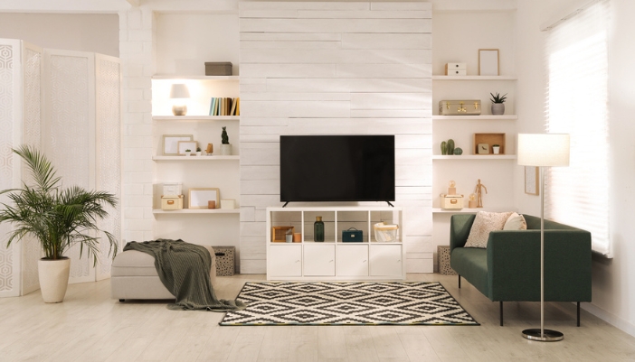 A warmly lit, modern living room with white and natural accents. 