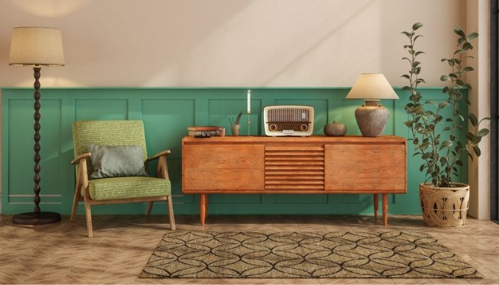 Warm living space with a green and wooden accented chair next to a vintage-inspired media console with a vinyl player on top.