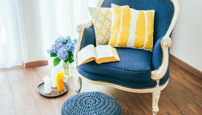 Blue armchair with yellow pillows, an open book on the seat