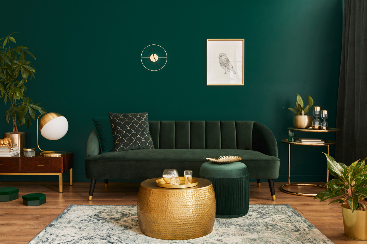 living room with green velvet sofa and gold accessories