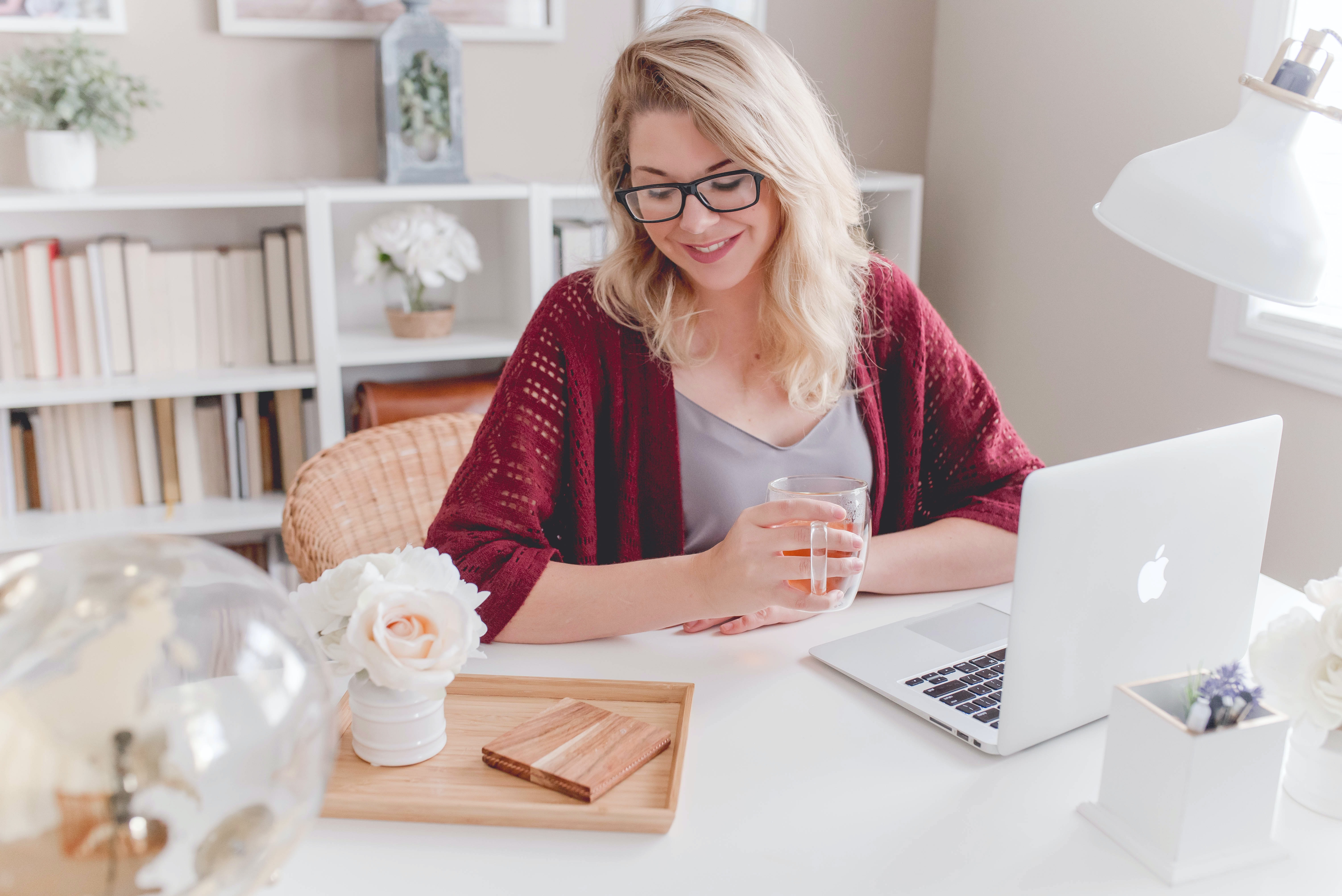 smiling woman sits comfortably in her beautiful home office