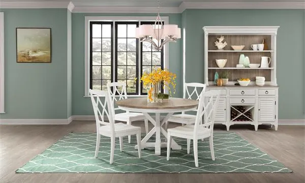 Credit: Riverside Furniture The Riverside Furniture Myra collection table with compatible collection pieces in a sage-themed dining room