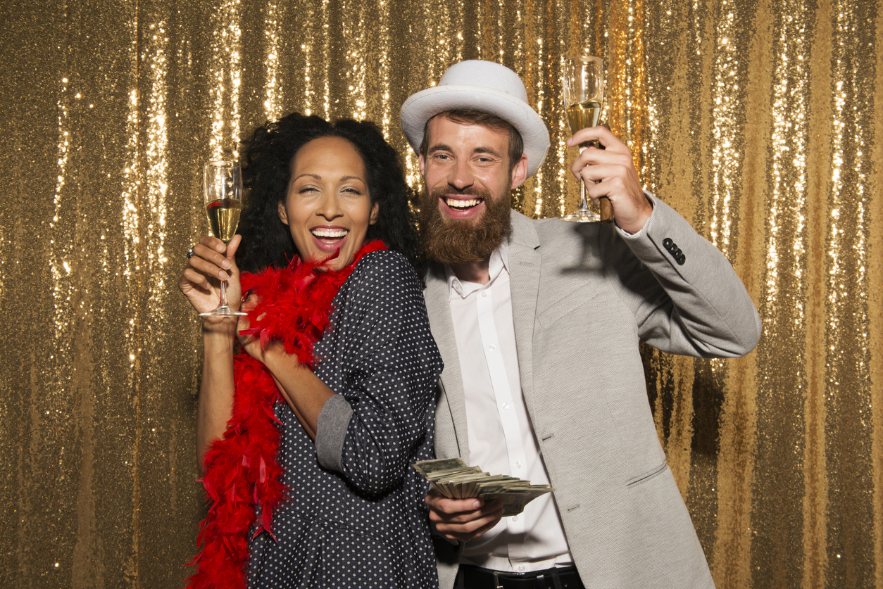 iStock Credit: simonkr portrait of smiling couple holding champagne flutes at party