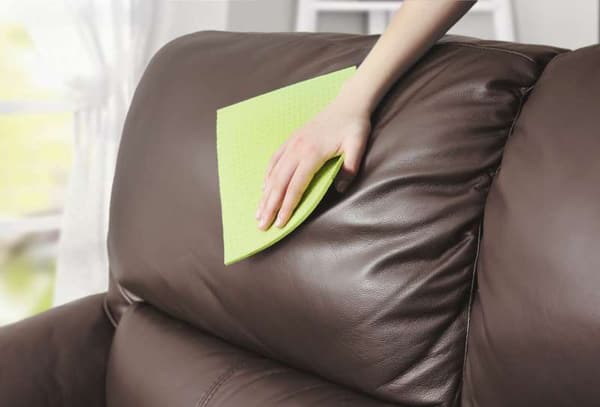 A person cleaning a leather seat