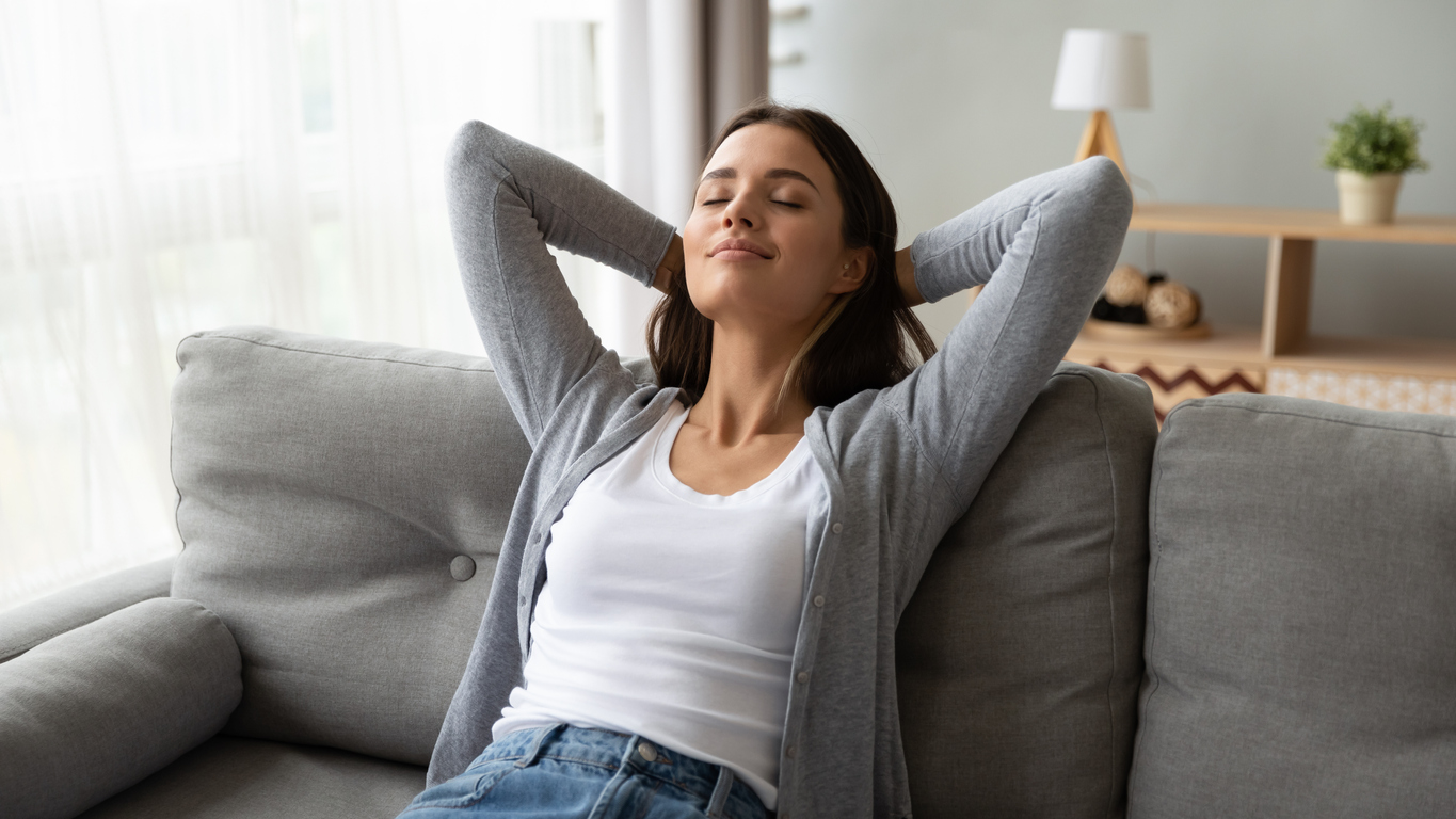 iStock Credit: fizkes woman leans back on new couch with relaxed expression