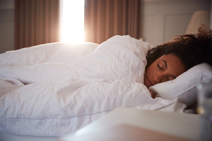 Woman waking up in bed with smile.