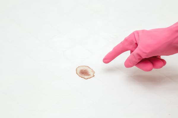 iStock Credit: FotoDuets A person in pink gloves pointing a blood stain on a mattress