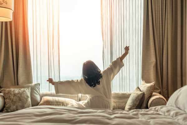 iStock Credit: Chinnapong A wide view of a woman stretching on a bed