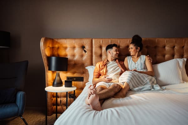 A woman and man smiling in a bed