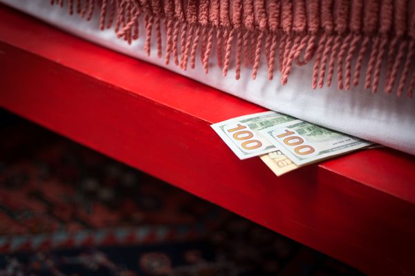 A close-up of bills under a mattress