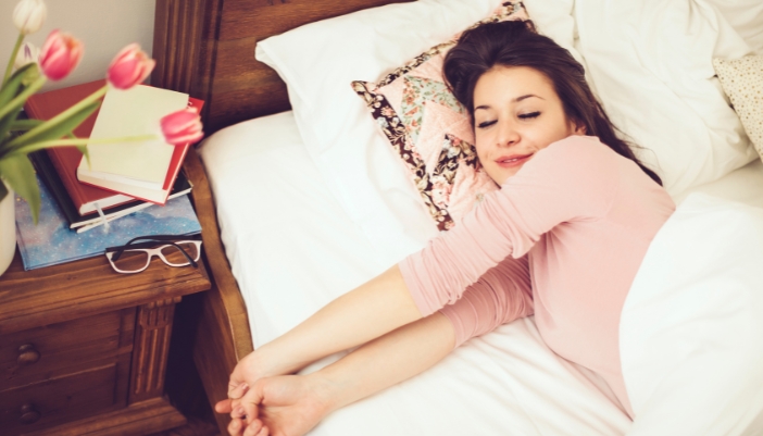 Woman waking up refreshed in the morning after a full night’s sleep