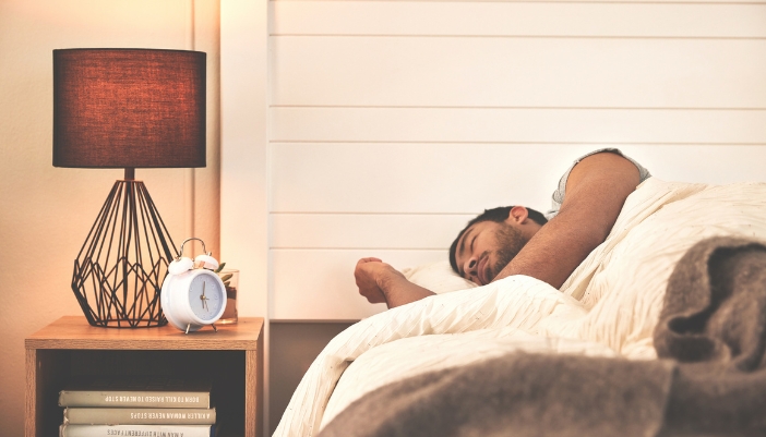 Matt_Reading-Before-Bed_3.jpg Man sleeping with a nightstand full of books next to him