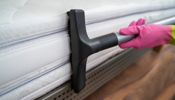 Closeup of someone vacuuming mattress