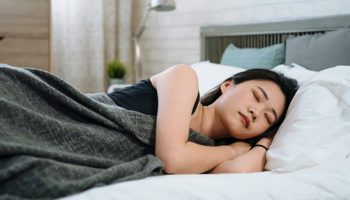 A man lays on his side to sleep.