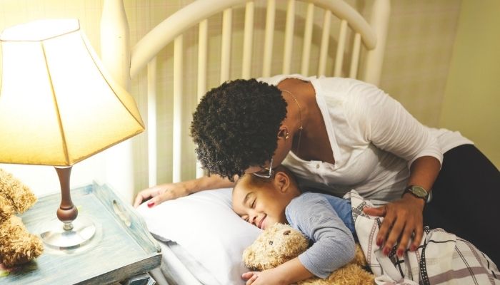 Mother kissing son goodnight