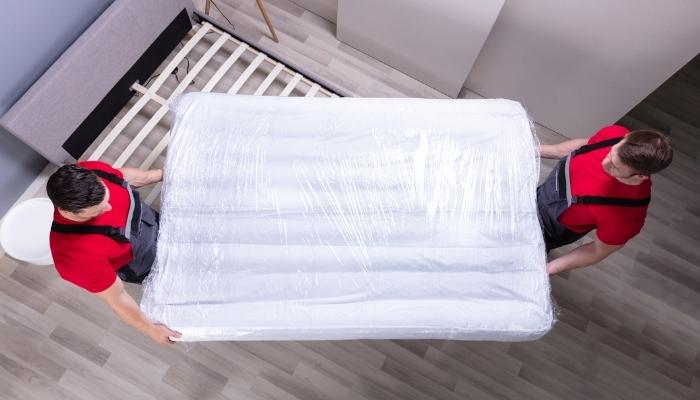 Matt_What-Happens-to-Old-Mattresses_1.jpg Two delivery men installing new mattress