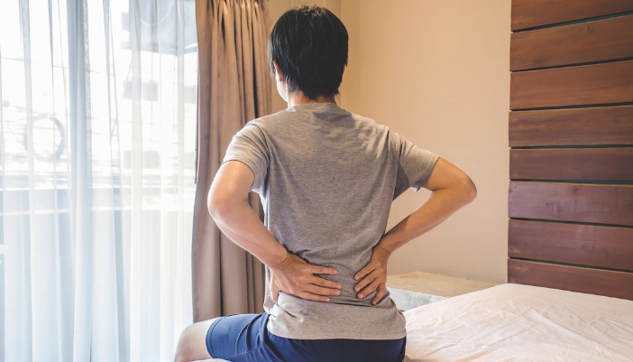 Matt_Bed-Height-Matters_1.jpg Man holding his lower back because his bed caused him pain