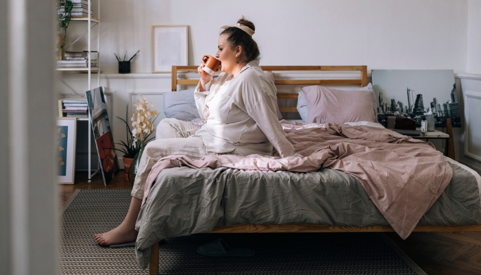 Matt_Bed-Height-Matters_2.jpg Woman drinking coffee while sitting on a bed of perfect height