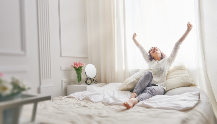 Matt_Bed-Height-Matters_5.jpg Woman waking up bright and enjoying the comfort of her bed