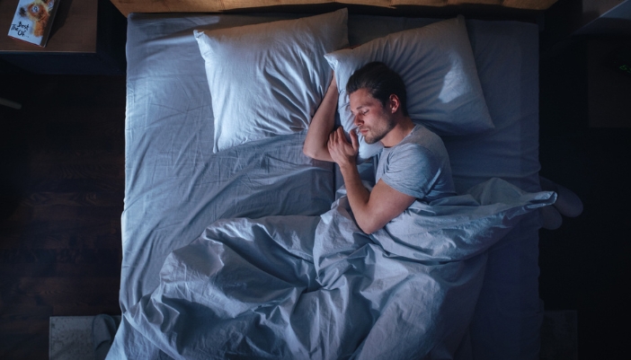 A man sleeps soundly at night in a new bed.