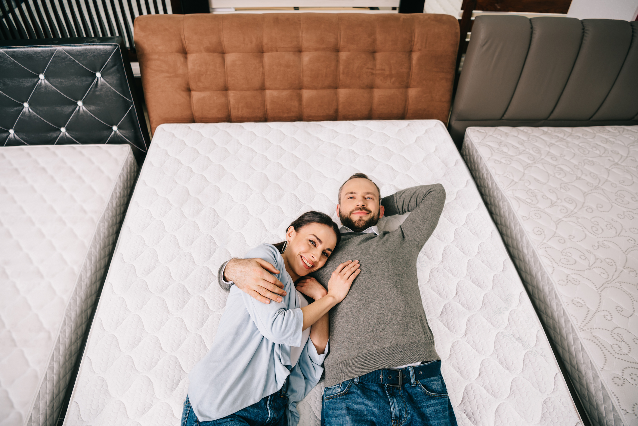Mattress Land couples mattress header smiling couple laying on mattress