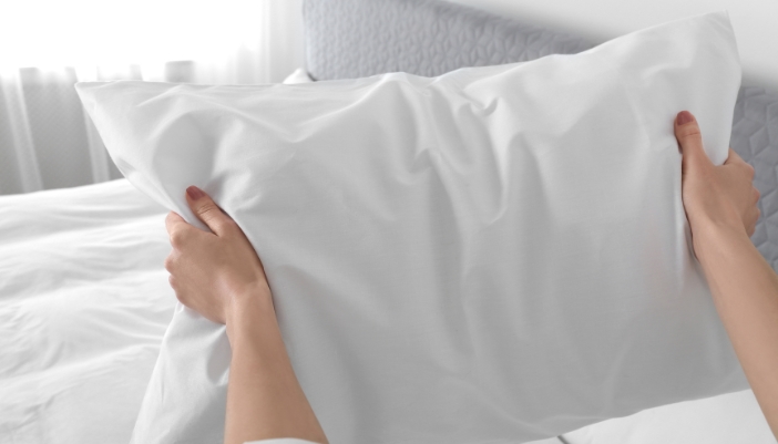 Matt_Find-Dream-Pillows_5.jpg Closeup of someone fluffing their pillow