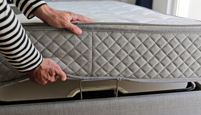 Matt_Sleep-Apnea-Bedding-Solutions_2.jpg Closeup of someone placing their mattress on top of an adjustable foundation