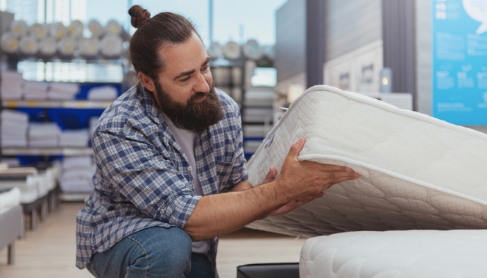 A man checks out a mattress in a showroom.