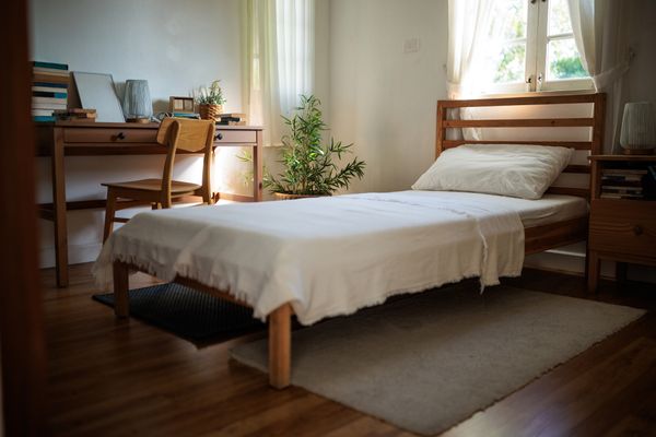 A wooden twin size mattress in a bedroom