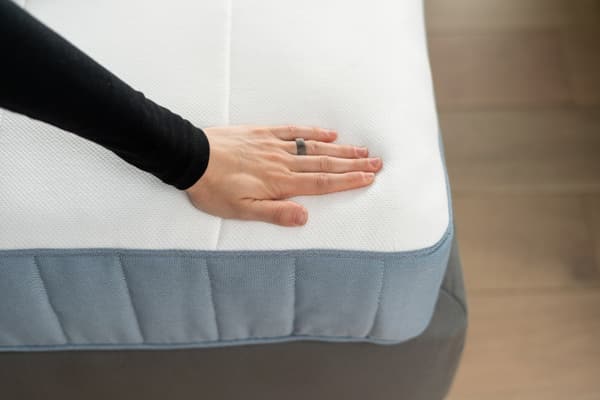 A person pressing on a mattress