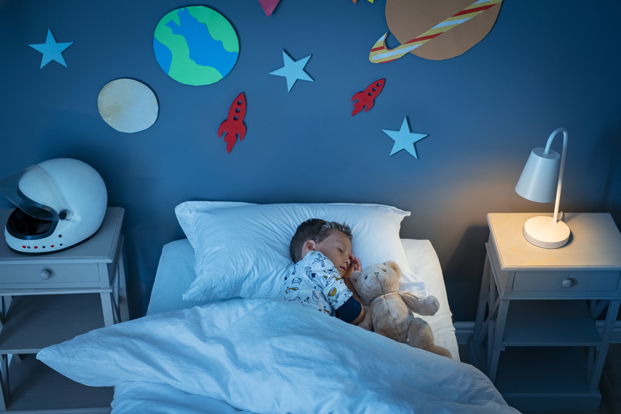 iStock Credit: Ridofranz child sleeping on bed with solar system and planet decoration during the night