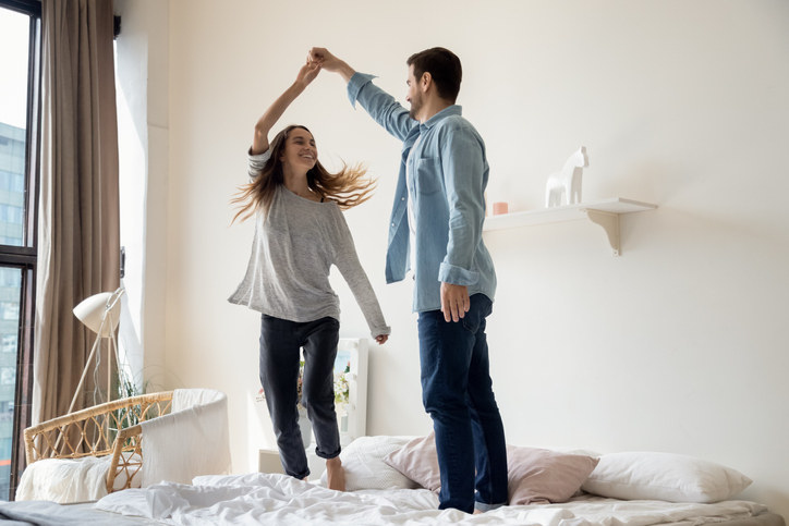 man and woman couple dance on top of bed