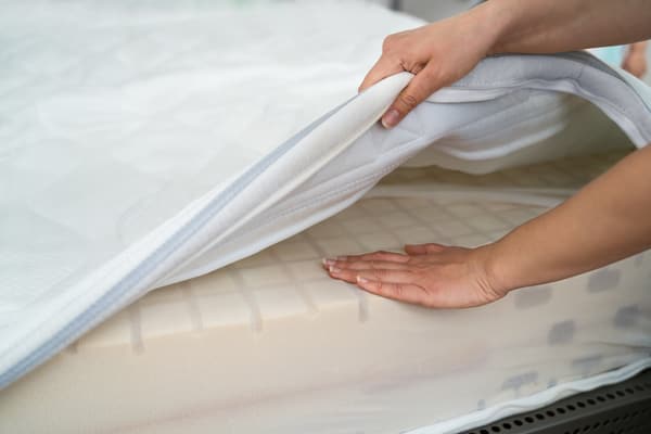 A person lifting a mattress cover