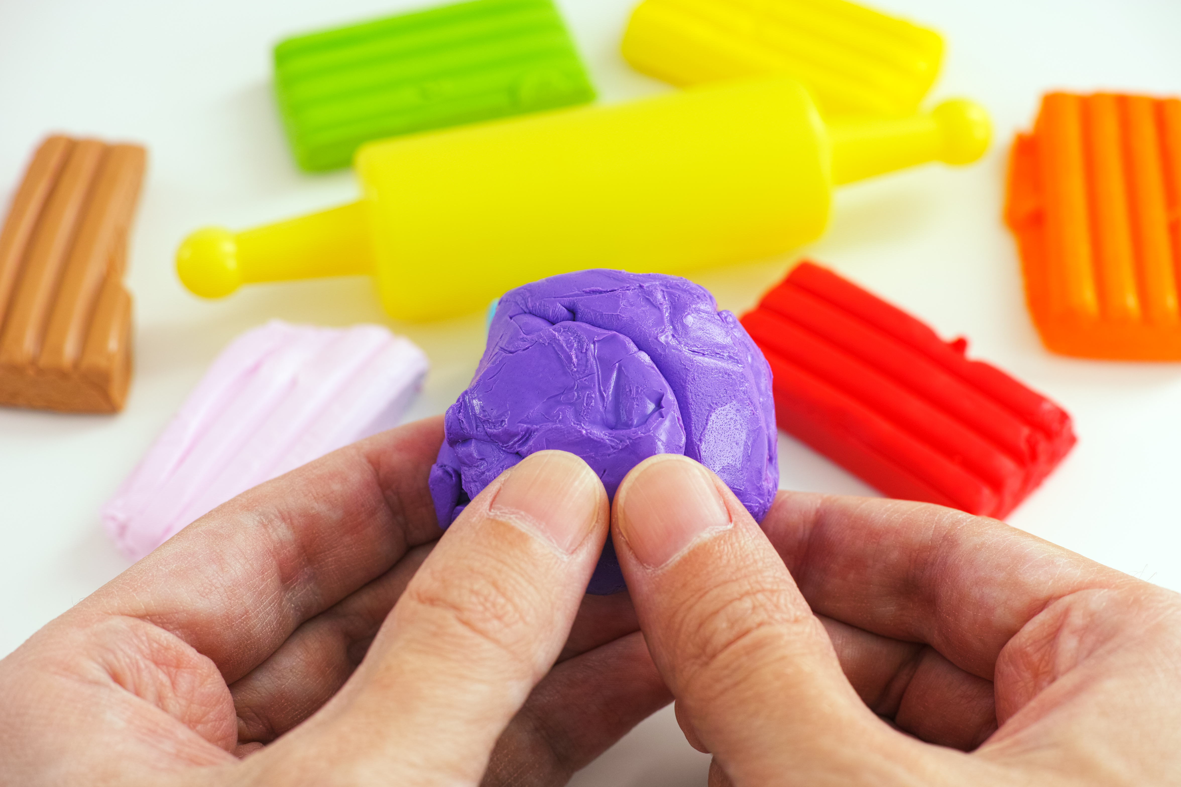 iStock Credit: Professor25 Person plays with several different colored clays