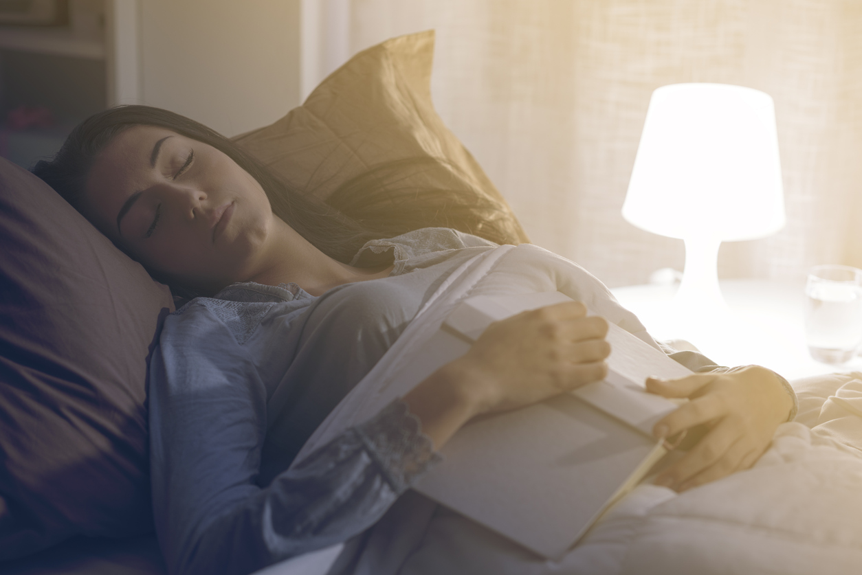 iStock Credit: cyano66 woman fallen asleep in bed while reading