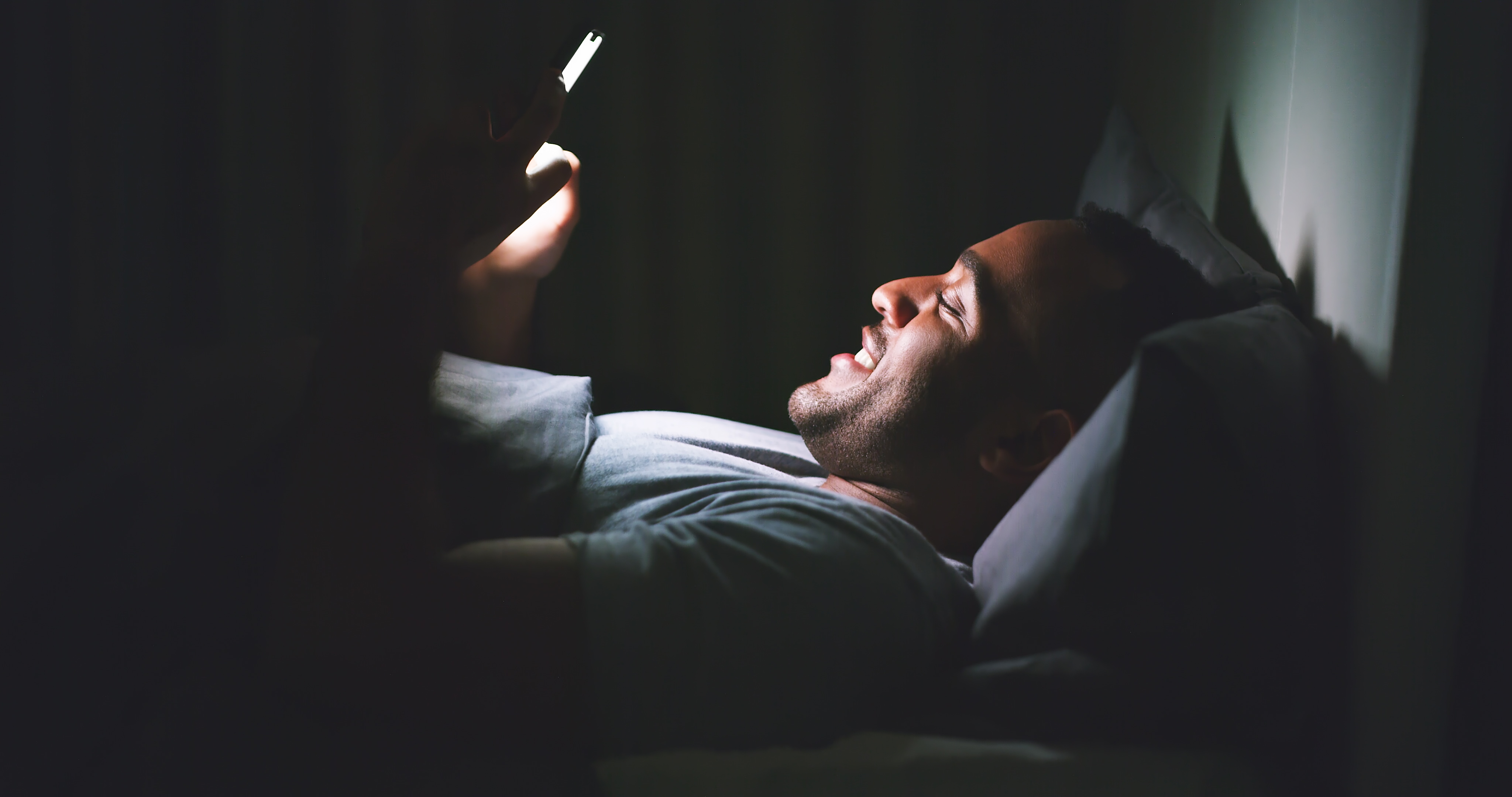 Cecilie_Arcurs man glued to his phone a nightime