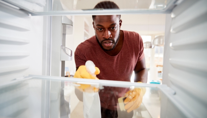 Closeup of man cleaning out the fridge after it defrosted